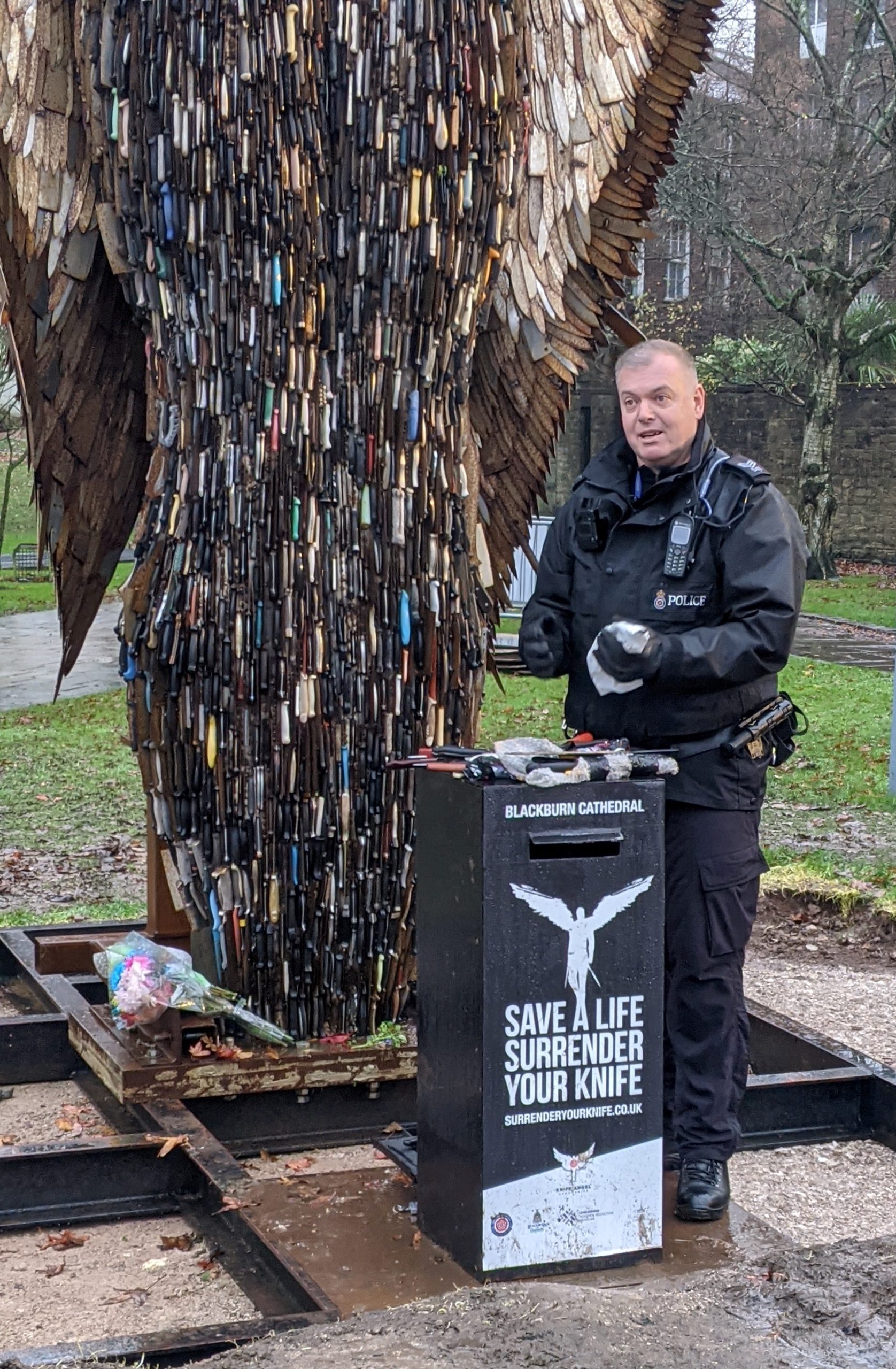 Knife bin at the Knife Angel being emptied by a police officer